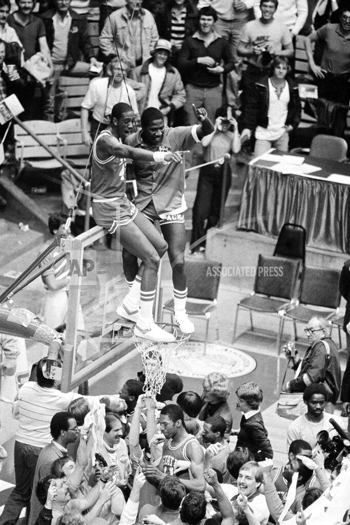 Anonymous FILE - In this April 5, 1983, file photo, North Carolina State players Cozell McQueen, left, and Ernie Myers celebrate while standing on the rim after defeating Houston 54-52 to win the NCAA college basketball championship in Albuquerque, N.M. (AP Photo/File)