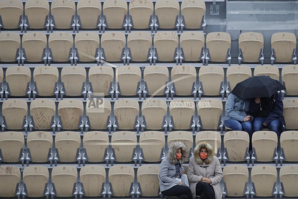 Alessandra Tarantino Spectators protect themselves from the cold as they watch the third round match of the French Open tennis tournament between France's Hugo Gaston and Switzerland's Stan Wawrinka at Suzanne Lenglen court at the Roland Garros stadium in Paris, France, Friday, Oct. 2, 2020. (AP Photo/Alessandra Tarantino)