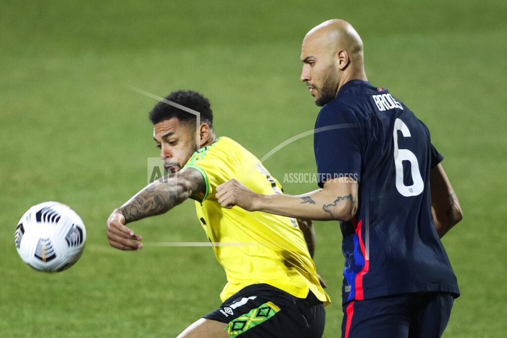 Ronald Zak USA's John Brooks, right, duels for the ball with Jamaica's Andre Gray during the international friendly soccer match between USA and Jamaica at SC Wiener Neustadt stadium in Wiener Neustadt, Austria, Thursday, March 25, 2021. (AP Photo/Ronald Zak)