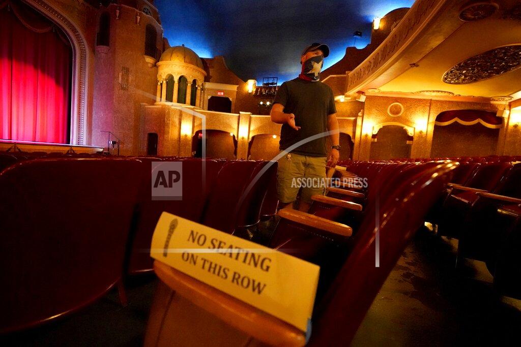 Tony Gutierrez Employee Grayson Allred responds to questions from a reporter while standing inside the Paramount Theatre on Wednesday, Dec. 16, 2020, in Abilene, Texas. The theatre has closed down indefinitely due to rising cases of COVID-19 in the city. (AP Photo/Tony Gutierrez)