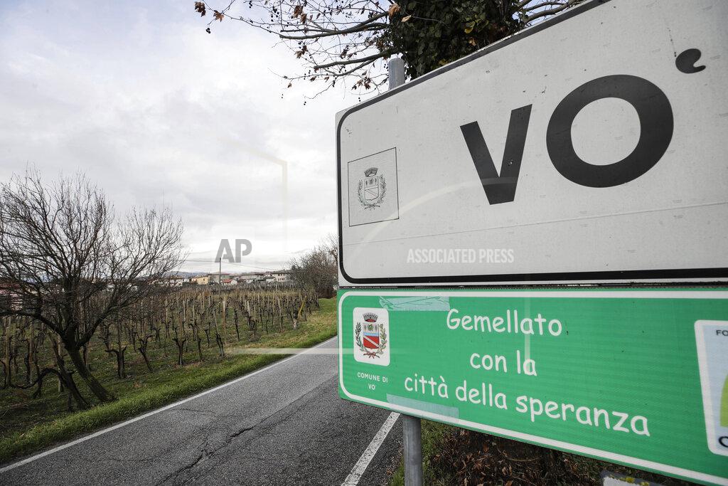 Luca Bruno A road sign indicates Vo ahead of the village of Vo' Euganeo, northern Italy, Wednesday, Feb. 10, 2021. Shockwaves ran through the wine-making village of Vo, west of Venice, as word spread last Feb. 21 that a retired roofer had died of the new coronavirus becoming the first known COVID-19 victim in the West. Writing on green sign reads in Italian "Twinned with the city of hope" (AP Photo/Luca Bruno)