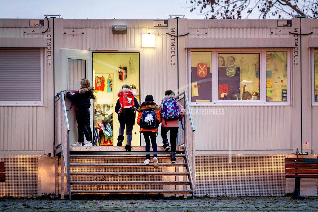 Michael Probst Pupils go to a school which is partially located in containers in Frankfurt, Germany, Monday, Dec. 14, 2020. Germany goes into a lockdown on Wednesday, Dec. 16, 2020. (AP Photo/Michael Probst)