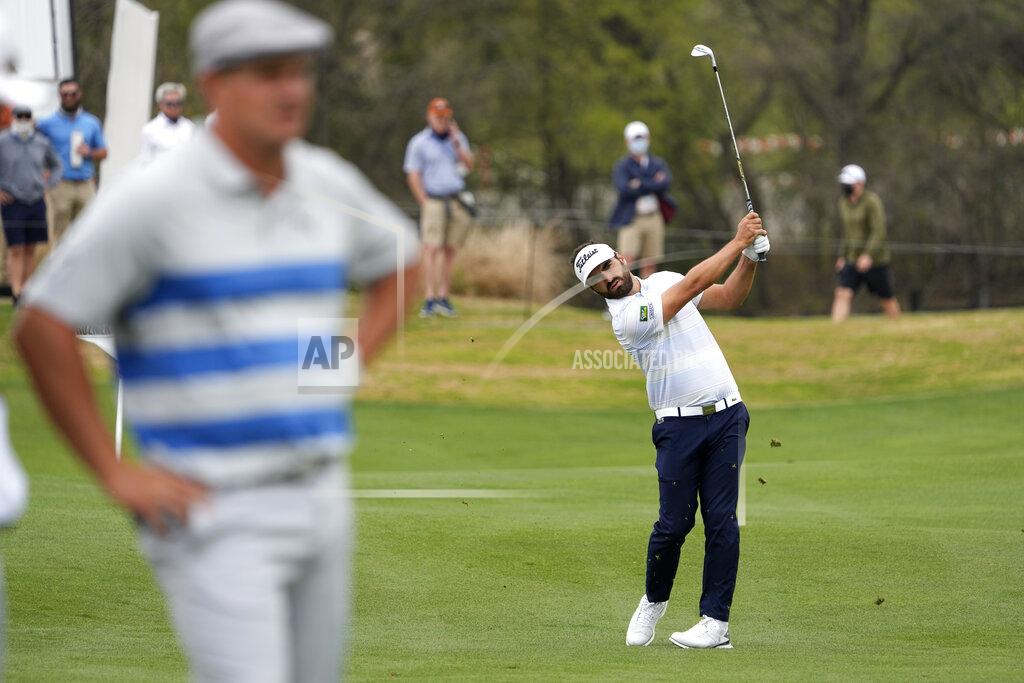 David J. Phillip Antoine Rozner, of France, playing against Bryson DeChambeau, left, hits his second shot on the 13th hole, during a first round match at the Dell Technologies Match Play Championship golf tournament Wednesday, March 24, 2021, in Austin, Texas. (AP Photo/David J. Phillip)