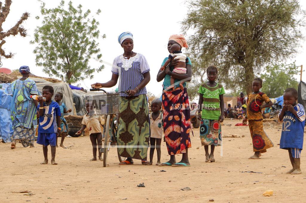Sam Mednick Women and children walk in a makeshift site for displaced people in Kongoussi, Burkina Faso Thursday, June 4, 2020. Jihadist violence has dramatically escalated in Burkina Faso in recent years. The country's military has struggled to contain the violence. (AP Photo/Sam Mednick)