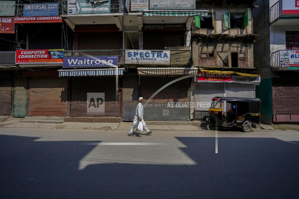 Mukhtar Khan A man walks through a closed market in Srinagar, Indian controlled Kashmir, Thursday, May 26, 2022. Police in disputed Kashmir arrested at least 10 youths during overnight raids following an anti-India protest that erupted as an Indian court sentenced a prominent Kashmiri pro-independence leader to life in prison, officials said Thursday. (AP Photo/Mukhtar Khan)