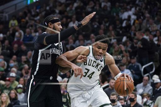 Milwaukee Bucks' Giannis Antetokounmpo (34) is defended by Brooklyn Nets' James Johnson during the first half of an NBA basketball game Tuesday, Oct. 19, 2021, in Milwaukee. (AP Photo/Morry Gash)