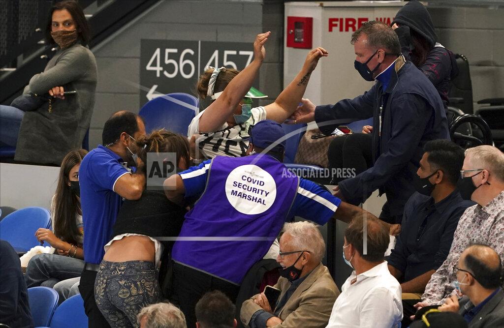 Mark Dadswell FILE - Women are ejected by security during the men's singles final match between Serbia's Novak Djokovic and Russia's Daniil Medvedev on Rod Laver Arena at the Australian Open tennis championship in Melbourne, Australia, in this Sunday, Feb. 21, 2021, file photo. (AP Photo/Mark Dadswell)