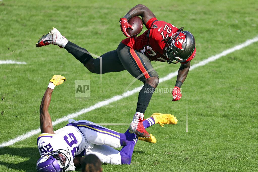 Mark Lomoglio Tampa Bay Buccaneers running back Ronald Jones II (27) gets tripped up by Minnesota Vikings defensive back Chris Jones (26) during the first half of an NFL football game Sunday, Dec. 13, 2020, in Tampa, Fla. (AP Photo/Mark LoMoglio)
