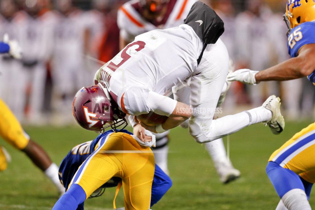 Keith Srakocic Virginia Tech quarterback Ryan Willis (5) flips after he is hit by Pittsburgh defensive lineman James Folston Jr. (40) on a run in the third quarter of an NCAA football game, Saturday, Nov. 10, 2018, in Pittsburgh. Pittsburgh won 52-22.(AP Photo/Keith Srakocic)