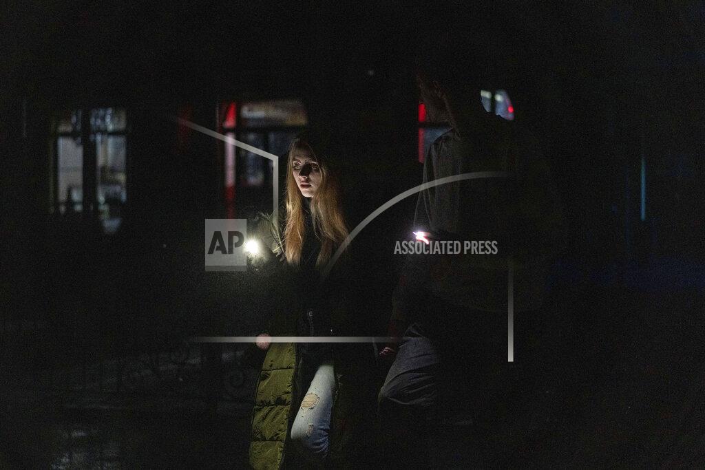 Evgeniy Maloletka A young couple walk at the city center which lost electrical power after yesterday's Russian rocket attack in Kyiv, Ukraine, Thursday, Nov. 24, 2022. (AP Photo/Evgeniy Maloletka)