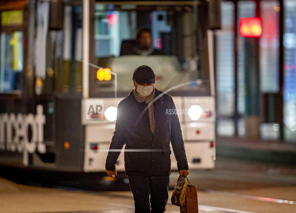 Michael Probst A man wearing a face mask walks in downtown Frankfurt, Germany, early Monday, Oct. 19, 2020. (AP Photo/Michael Probst)