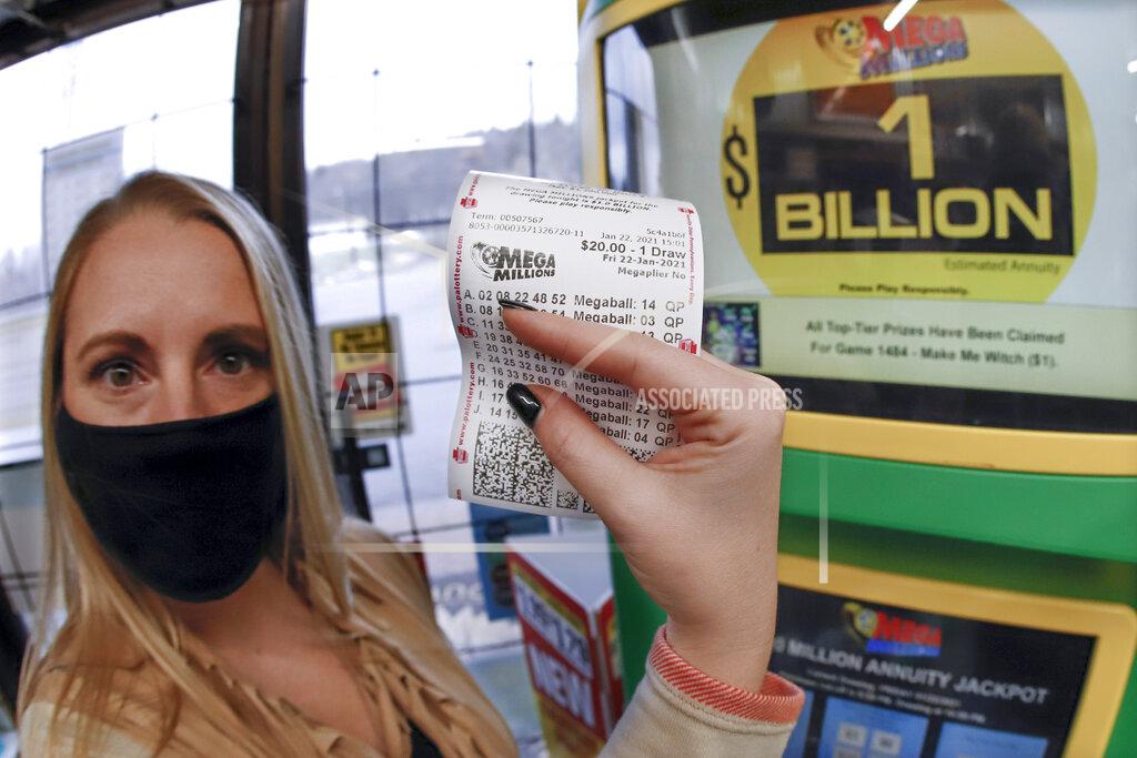Keith Srakocic A patron, who did not want to give her name, shows the ticket she had just purchased for the Mega Millions lottery drawing at the lottery ticket vending kiosk in a Smoker Friendly store, Friday, Jan. 22, 2021, in Cranberry Township, Pa. The jackpot for the Mega Millions lottery game has grown to $1 billion ahead of Friday night's drawing after more than four months without a winner. (AP Photo/Keith Srakocic)
