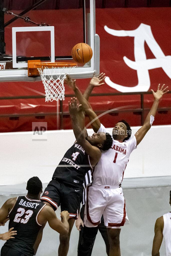 Vasha Hunt Alabama forward/guard Herbert Jones (1) is called for a goal-tend as Western Kentucky guard Josh Anderson (4) shoots during the second half of an NCAA college basketball game, Saturday, Dec. 19, 2020, in Tuscaloosa, Ala. The goal tend with only seconds to play gave Western Kentucky the final margin of 73-71.(AP Photo/Vasha Hunt)