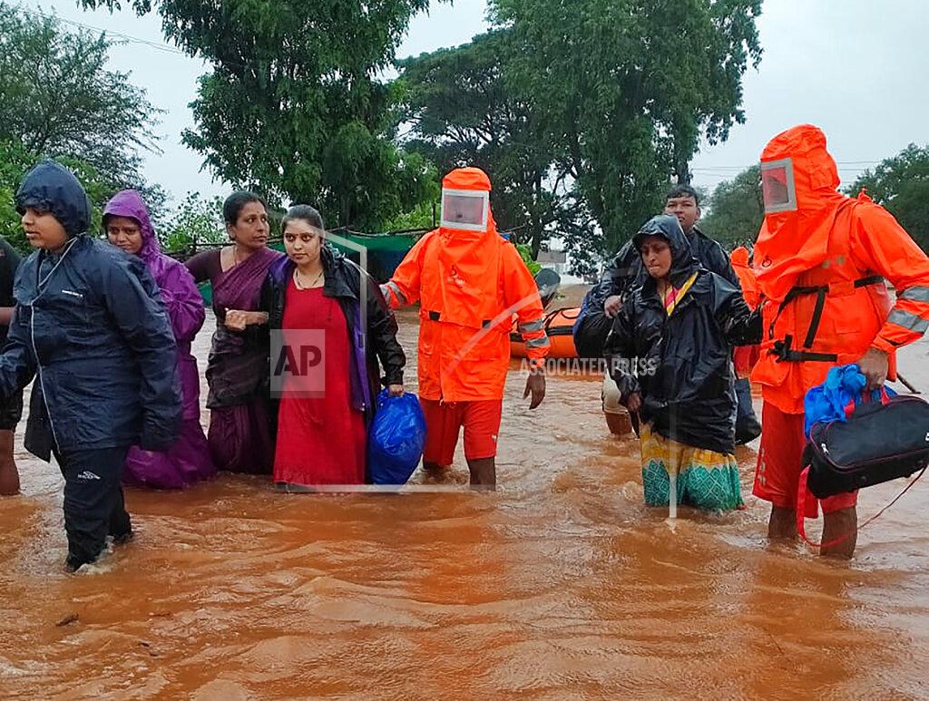 Uncredited This photograph provided by India's National Disaster Response Force (NDRF) shows NDRF personnel rescuing people stranded in floodwaters in Chikhali, in the western Indian state of Maharashtra, Friday, July 23, 2021. Landslides triggered by heavy monsoon rains hit parts of western India, killing more than 30 people and leading to the overnight rescue of more than 1,000 other people trapped by floodwaters, officials said Friday.(National Disaster Response Force via AP)