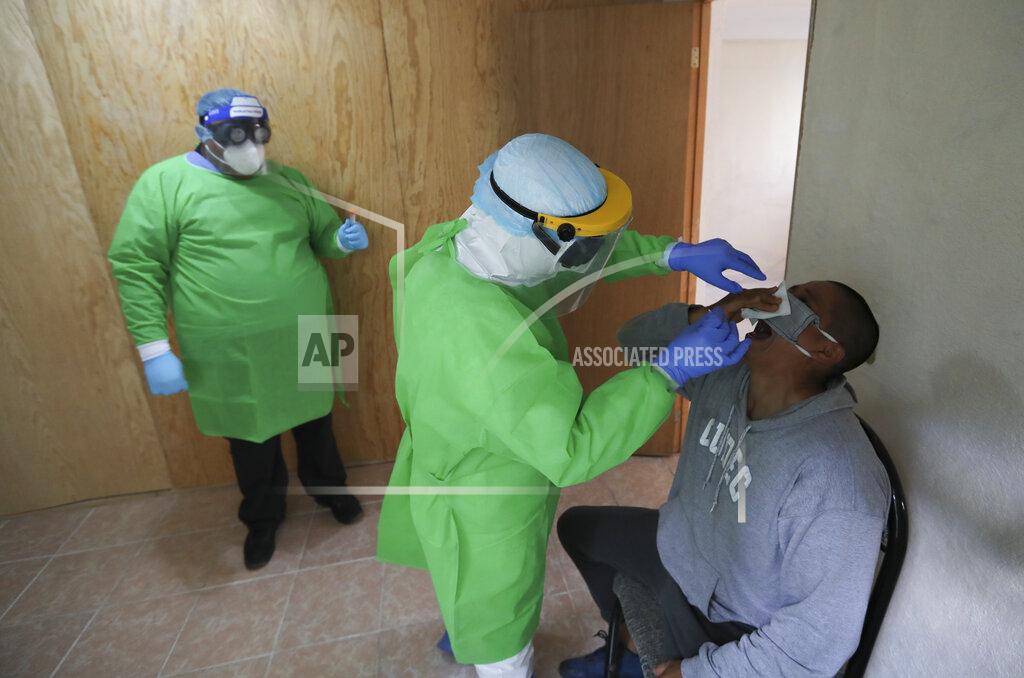 Eduardo Verdugo Health worker Ivan Mandujano collects a nasal swab sample from a resident to test for COVID-19, in Xochimilco, Mexico City, Wednesday, Aug. 5, 2020. (AP Photo/Eduardo Verdugo)