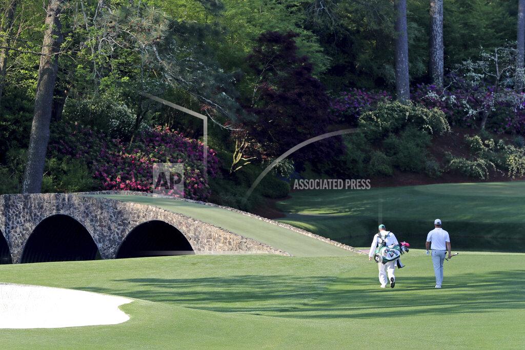 Curtis Compton Bryson DeChambeau and his caddy Tim Tucker walks toward the Ben Hogan bridge and the 12th hole during a practice round for the Masters golf tournament in Augusta, Ga., Wednesday, April 7, 2021. (Curtis Compton/Atlanta Journal-Constitution via AP)