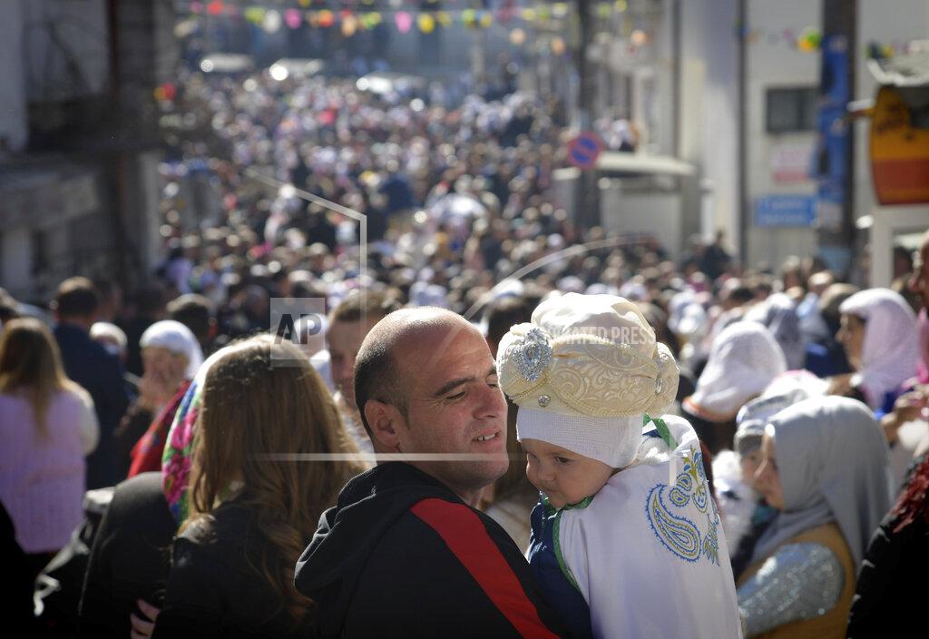 Jordan Simeonov A father holds his son as they take part in a mass circumcision ceremony in the village of Ribnovo, Bulgaria, Sunday, April 11, 2021. Despite the dangers associated with COVID-19 and government calls to avoid large gatherings, Hundreds of people flocked to the tiny village of Ribnovo in southwestern Bulgaria for a four-day festival of feasting, music and the ritual of circumcision which is considered by Muslims a religious duty and essential part of a man's identity. (AP Photo/Jordan Simeonov)