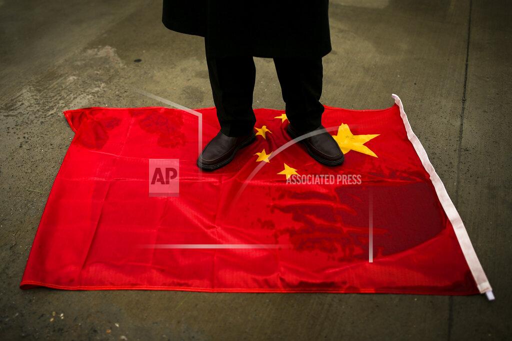 Emrah Gurel A protester from the Uyghur community living in Turkey steps on a China flag during a protest against the visit of China's Foreign Minister Wang Yi to Turkey, in Istanbul, Thursday, March 25, 2021. Hundreds of Uyghurs staged protests in Istanbul and the capital Ankara, denouncing Wang Yi's visit to Turkey and demanding that the Turkish government take a stronger stance against human rights abuses in China's far-western Xinjiang region. (AP Photo/Emrah Gurel)