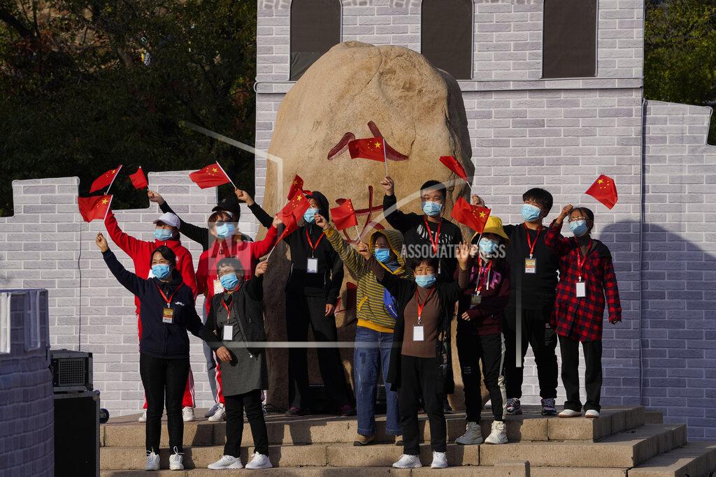 Ng Han Guan Performers wearing masks to protect from the coronavirus wave national flags as they rehearse for a show at the Badaling Great Wall of China on the outskirts of Beijing on Tuesday, Oct. 6, 2020. Chinese tourists took 425 million domestic trips in the first half of the eight-day National Day holiday, generating $45.9 billion in tourism revenue, according to China's ministry of culture and tourism. The holiday this year, which coincides with the Mid-Autumn Festival, will be a litmus test of whether China's tourism industry can bounce back after being battered by COVID-19. (AP Photo/Ng Han Guan)