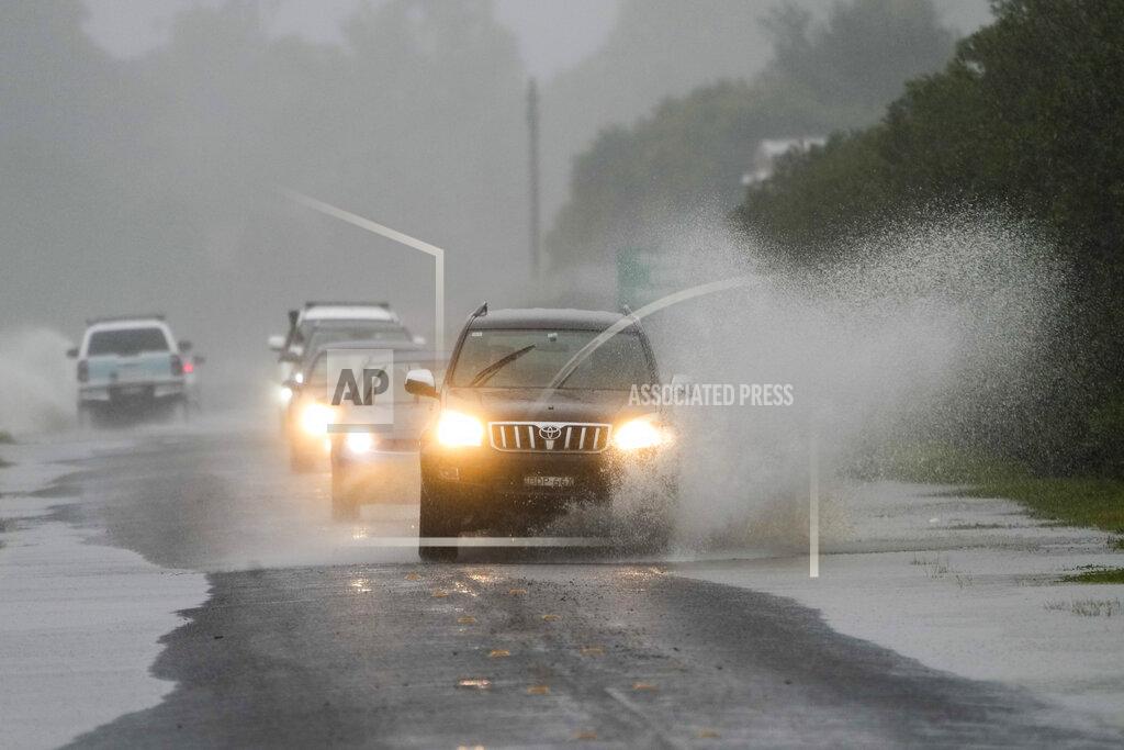 Mark Baker Cars drive through flood waters in Richmond on the outskirts of Sydney, Australia, Monday, July 4, 2022. More than 30,000 residents of Sydney and its surrounds have been told to evacuate or prepare to abandon their homes on Monday as Australia's largest city braces for what could be its worst flooding in 18 months.(AP Photo/Mark Baker)