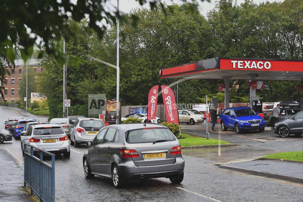 Anthony Devlin Cars queue at a petrol station in Stalybridge, England, Saturday Sept. 25, 2021. The haulage industry says the U.K. is short tens of thousands of truckers, due to a perfect storm of factors including the coronavirus pandemic, an aging workforce and an exodus of European Union workers following Britain’s departure from the bloc. BP and Esso shut a handful of their gas stations this week, and motorists have formed long lines as they try to fill up in case of further disruption. (Anthony Devlin/PA via AP)