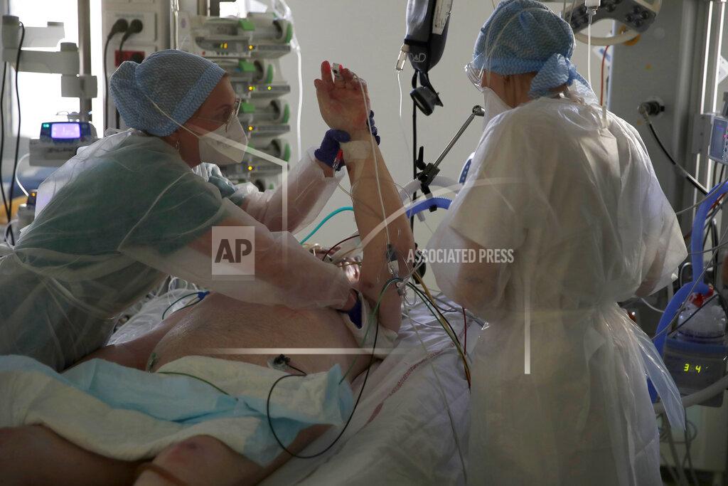 Francois Mori Medical workers tend to a patient affected with the COVID-19 at the Amiens Picardie hospital, Tuesday, March 30, 2021, in Amiens, 160 km (100 miles) north of Paris. The number of patients in intensive care in France on Monday surpassed the worst point of the country's last coronavirus surge in the autumn of 2020, another indicator of how a renewed crush of infections is bearing down on French hospitals. (AP Photo/Francois Mori)
