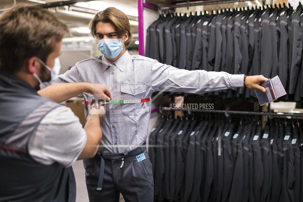 Alessandro Della Valle Michael Maeder from the equipment staff, left, measures the chest of 21 year old Swiss Ice Hockey player Nico Hischier, center at NHL club New Jersey Devils, as the latter receives his Swiss army uniform in Wangen an der Aare, Switzerland, Tuesday, June 16, 2020. Hischier completes part of his mandatory army service for elite athletes with an 18 week recruit training. (Alessandro della Valle/Keystone via AP)