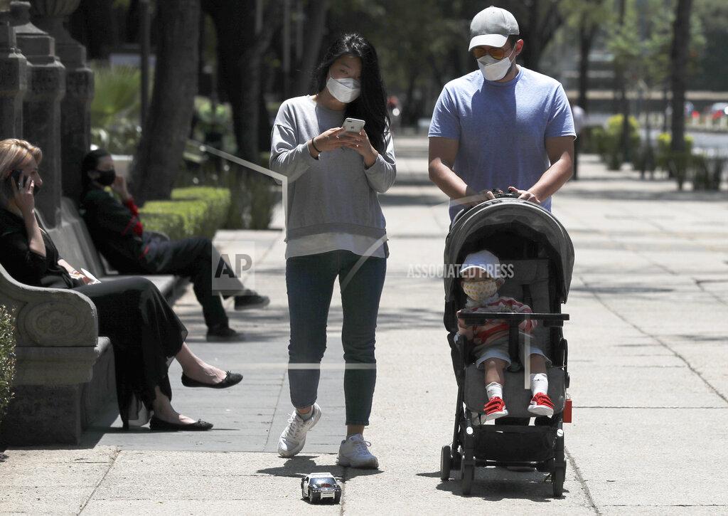 Marco Ugarte A family wears a protective mask as a precaution against the spread of the new coronavirus in Mexico City, Monday, April 27, 2020. (AP Photo/Marco Ugarte)