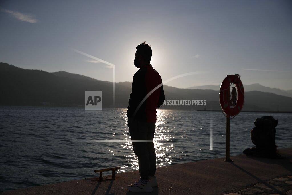 Thanassis Stavrakis An Afghan father stands at the port of Vathy on the eastern Aegean island of Samos, Greece, Monday, Feb. 22, 2021. On a hill above a small island village, the sparkling blue of the Aegean just visible through the pine trees, lies a boy’s grave. His first ever boat ride was to be his last - the sea claimed him before his sixth birthday. His 25-year-old father, like so many before him, had hoped for a better life in Europe, far from the violence of his native Afghanistan. But his dreams were dashed on the rocks of Samos, a picturesque Greek island almost touching the Turkish coast. Still devastated from losing his only child, the father has now found himself charged with a felony count of child endangerment. (AP Photo/Thanassis Stavrakis)