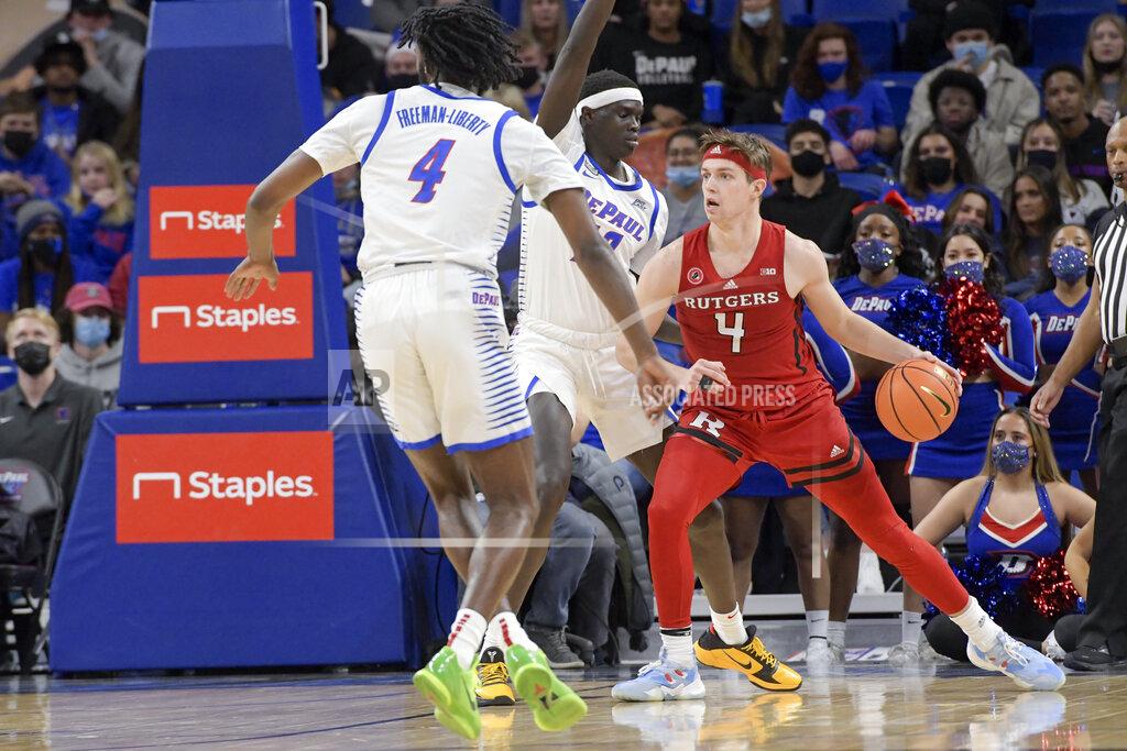 Mark Black Rutgers' Paul Mulcahy (4) pushes toward the basket against DePaul's Javon Freeman-Liberty (4) and Yor Anei (10) during the second half of an NCAA college basketball game Thursday, Nov. 18, 2021, in Chicago. (AP Photo/Mark Black)