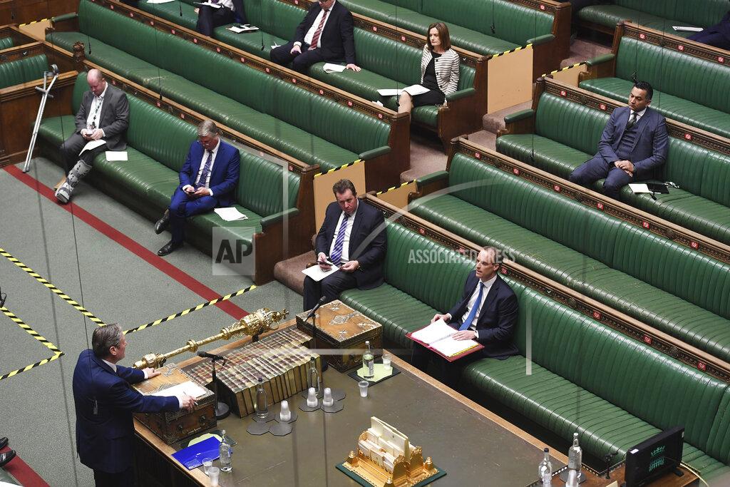 Jessica Taylor In this photo released by the UK Parliament, showing opposition Labour Party leader Keir Starmer, left, faces Dominic Raab, front right, inside of the House of Commons as members practice social distancing measures to combat COVID-19 coronavirus, as parliament goes online with most members of parliament participating via a video link, during Prime Minister's Questions time in London, Wednesday April 22, 2020. Dominic Raab answers questions, standing in for Prime Minister Boris Johnson who is still convalescing after contracting COVID-19 coronavirus. (Jessica Taylor/UK Parliament via AP)