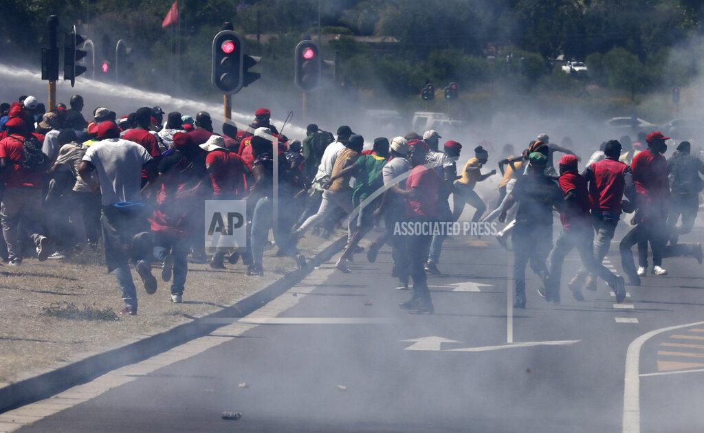 Nardus Engelbrecht Members of the Economic Freedom Fighters (EFF) flee from teargas, stun grenades and water canons fired by police during a protest near the Brackenfell High school in Cape Town, South Africa, Friday, Nov. 20, 2020. The EFF party organized protests at the school in response to a students' prom they claim only white kids were invited to. (AP Photo/Nardus Engelbrecht)