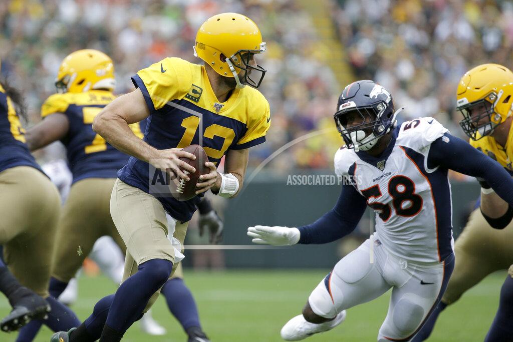 Green Bay Packers quarterback Aaron Rodgers (12) rolls out as as Denver Broncos outside linebacker Von Miller (58) rushes during the first half of an NFL football game Sunday, Sept. 22, 2019, in Green Bay, Wis. (AP Photo/Mike Roemer)