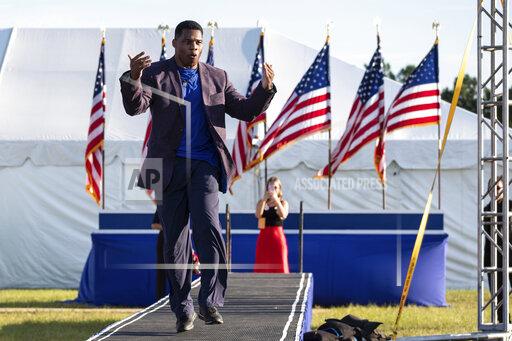 FILE - Senate candidate Herschel Walker takes the stage during former president Donald Trump's Save America rally in Perry, Ga., on Saturday, Sept. 25, 2021. Walker canceled a planned Texas fundraiser on Wednesday, Oct. 13 because an organizer was displaying a swastika made from syringes on social medial to protest mandatory vaccination. (AP Photo/Ben Gray, File)