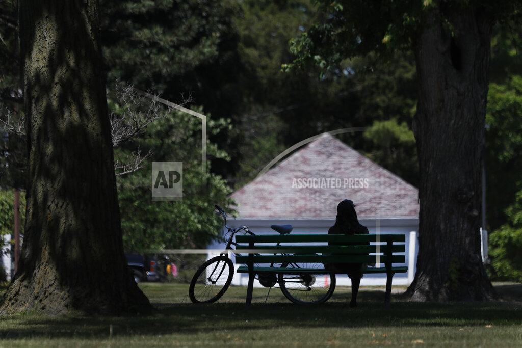 Charles Rex Arbogast A cyclist sits on a Hoyt Park bench Monday, June 29, 2020, in Saginaw, Mich. The county is majority-white and one-fifth the population is Black. (AP Photo/Charles Rex Arbogast)