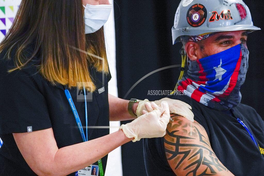 FILE - In this April 14, 2021 file photo, a Northwell Health nurse injects Local 28 Sheet Metal Worker Demetrius Buttelman with the first dose of the Pfizer vaccine during a news conference, at the Belmont Park in Elmont, N.Y. The state recorded 43,000 new cases in the week that ended Saturday, April 17, 2021. That's the lowest number in a seven-day period since Thanksgiving. (AP Photo/Mary Altaffer, Pool, File)
