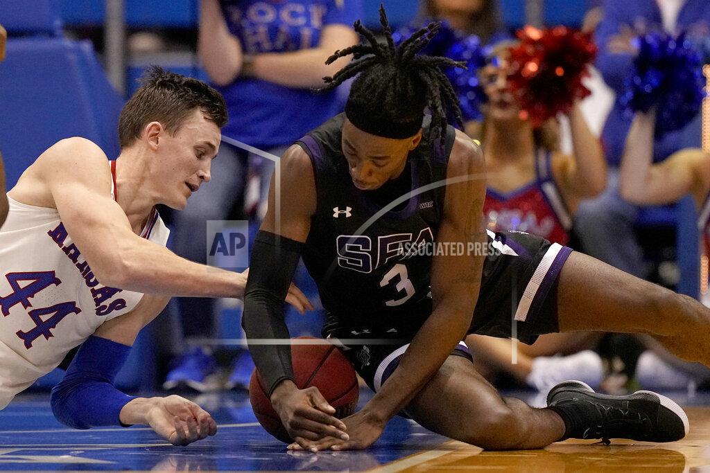 Charlie Riedel Kansas' Mitch Lightfoot (44) and Stephen F. Austin's Sadaidriene Hall (3) scramble for a loose ball during the second half of an NCAA college basketball game Saturday, Dec. 18, 2021, in Lawrence, Kan. (AP Photo/Charlie Riedel)