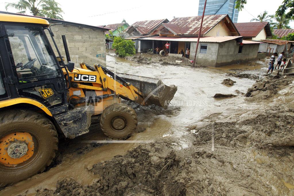 Kandhi Barnez A heavy machinery clears up mud from a neighborhood following a flood in Dili, East Timor, Monday, April 5, 2021. Multiple disasters caused by torrential rains in eastern Indonesia and neighboring East Timor have left a number of people dead or missing as rescuers were hampered by damaged bridges and roads and a lack of heavy equipment Monday. (AP Photo/Kandhi Barnez)