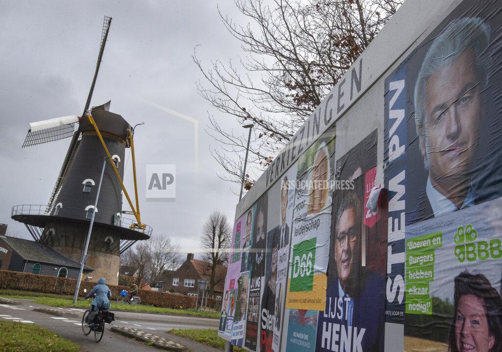 Peter Dejong Populist Dutch anti-immigration lawmaker Geert Wilder's election poster, top right, sits with others on a bilboard outside windmill the Kerhovense Molen which serves as polling station during general election in Oisterwijk, Netherlands, Wednesday, March 17, 2021. Polling stations have opened opened across the Netherlands from Monday in a general election that has been spread over three days to allow people to vote safely during the coronavirus pandemic. (AP Photo/Peter Dejong)