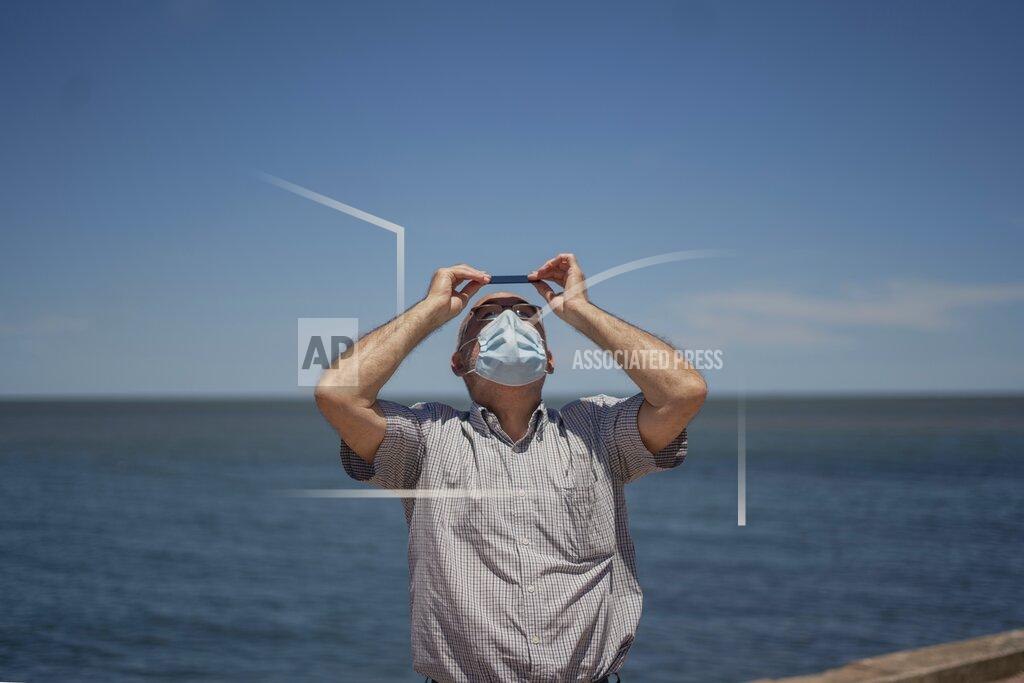 Matilde Campodonico A man observes a partial solar eclipse from Montevideo, Uruguay, Monday, Dec. 14, 2020. A total solar eclipse was visible from Chile and the northern Patagonia region of Argentina, and as a partial solar eclipse in Bolivia, Brazil, Ecuador, Paraguay, Peru and Uruguay.(AP Photo/Matilde Campodonico)