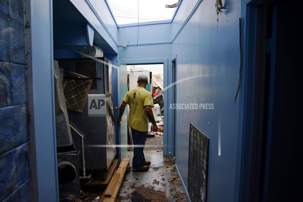 John Locher Blakland Matherne opens a door to what would have lead to an indoor shop, but is now outside after the roof was blown off, at his hurricane destroyed business in the aftermath of Hurricane Ida, Monday, Sept. 6, 2021, in Lockport, La. (AP Photo/John Locher)