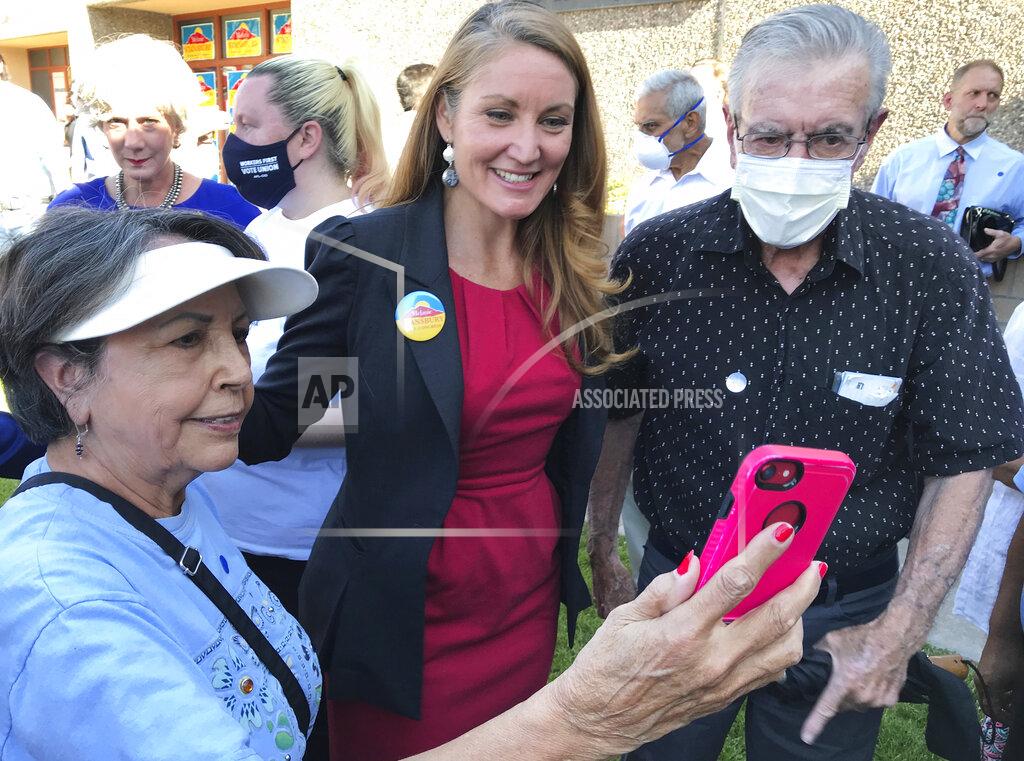 Susan Montoya Bryan Democratic congressional candidate Melanie Stansbury, center, takes photos with supporters during a campaign rally in Albuquerque, New Mexico, on Thursday, May 27, 2021. She was joined by Doug Emhoff, the husband of Vice President Kamala Harris. The trip marked Emhoff's first on behalf of a candidate. (AP Photo/Susan Montoya Bryan)