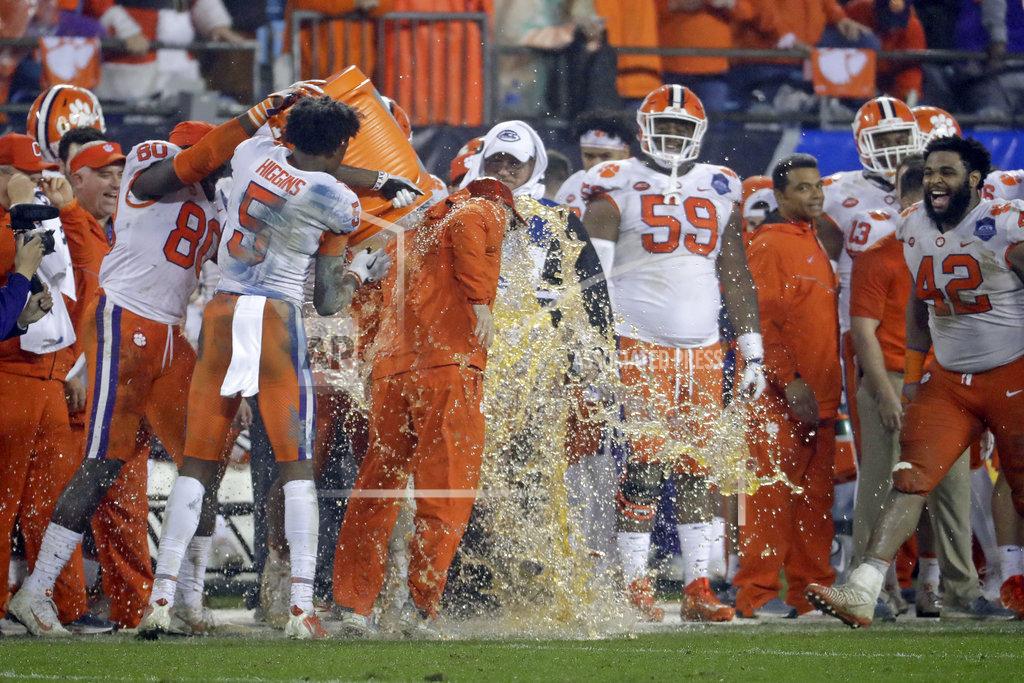 Chuck Burton Players dunk Clemson head coach Dabo Swinney, center, in the closing moments of the second half of the Atlantic Coast Conference championship NCAA college football game against Pittsburgh in Charlotte, N.C., Saturday, Dec. 1, 2018. (AP Photo/Chuck Burton)