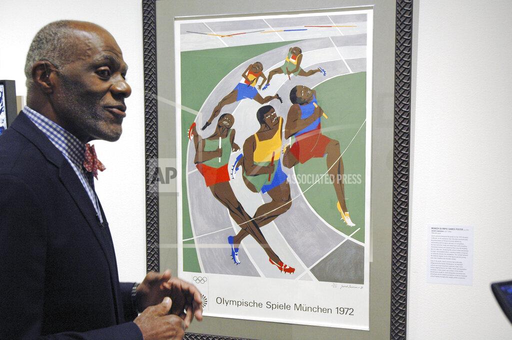 Steve Karnowski File-In this Jan. 11, 2018 file photo, Alan Page, NFL Hall of Famer and retired Minnesota Supreme Court justice, talks about a poster from the 1972 Olympics in Munich that was done by an African-American artist, which is among the artifacts of slavery and segregation collected by Page and his wife, Diane Sims Page. Page has counted art collection among his many life pursuits, and the former Vikings star has two of his prized pieces up for sale through a New York auction house, each valued at more than $200,000. (AP Photo/Steve Karnowski, File)