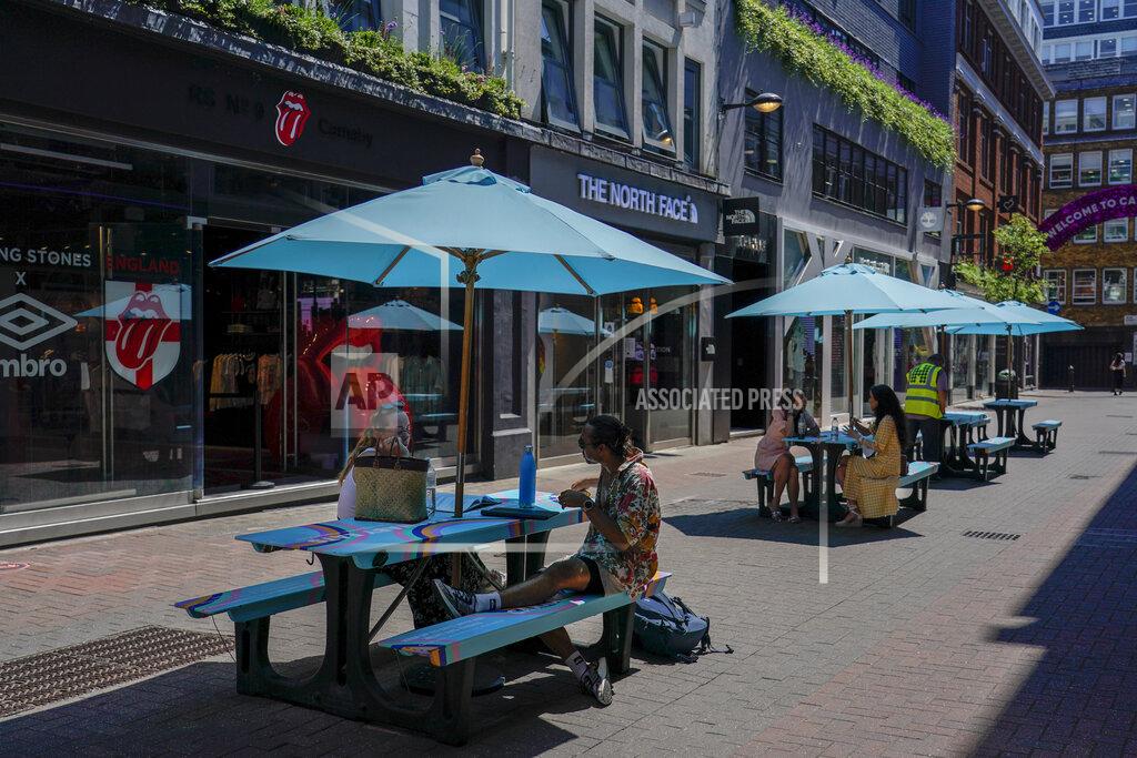 Alberto Pezzali People sit at outdoor tables in Carnaby Street, in London, Monday, June 14, 2021. British Prime Minister Boris Johnson is expected to confirm Monday that the next planned relaxation of coronavirus restrictions in England will be delayed as a result of the spread of the delta variant first identified in India. (AP Photo/Alberto Pezzali)