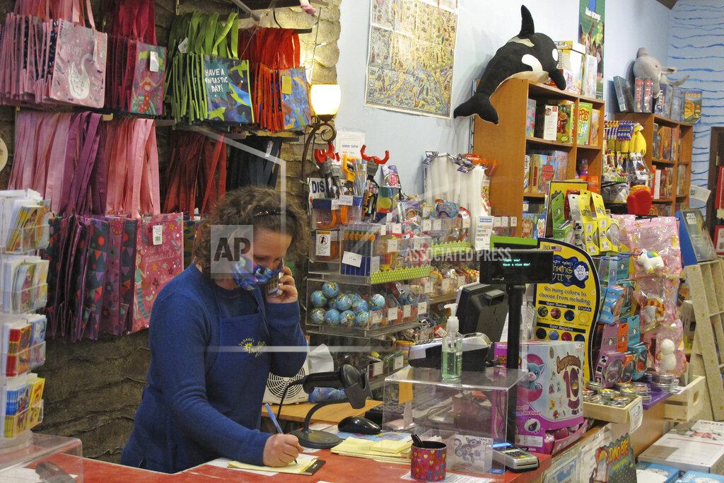 Becky Bohrer Alicia Smith, owner of Juneau's Imagination Station, jots notes while taking a call on Friday, April 24, 2020, in Juneau, Alaska. She said the specialty toy store has been doing curbside pickup and starting Tuesday will offer limited store hours with limited numbers of shoppers inside. (AP Photo/Becky Bohrer)