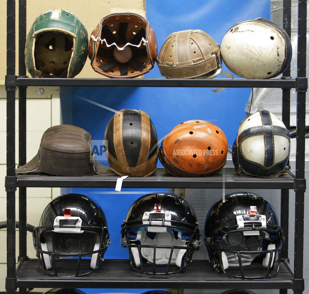 Mark Duncan FILE - In this Sept. 23, 2010, file photo, various football helmets, used for testing helmet-to-helmet collisions, are displayed on a rack at a laboratory in the Cleveland Clinic's Lutheran Hospital in Cleveland. Helmets have evolved from the original hard leather of the NFL’s infancy to hard polycarbonate single-piece shells with various amounts of padding and air bladders that served as the primary form of head protection into the beginning of this century. (AP Photo/Mark Duncan, File)