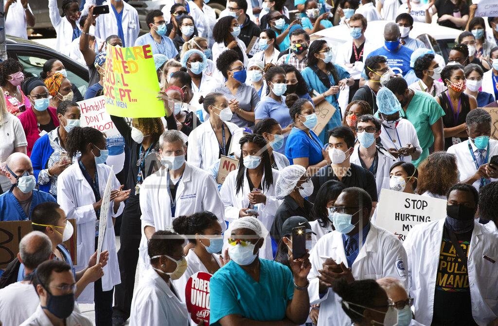 Mark Lennihan FILE - In this June 4, 2020, file photo, health care workers at Brooklyn's Kings County Hospital show their solidarity with Black Lives Matter during a demonstration in New York. Workers in New York City-run hospitals and health clinics will have to get vaccinated or get tested weekly under a policy announced Wednesday, July 21, 2021, to battle a rise in COVID-19 cases fueled by the highly contagious delta variant. (AP Photo/Mark Lennihan, File)