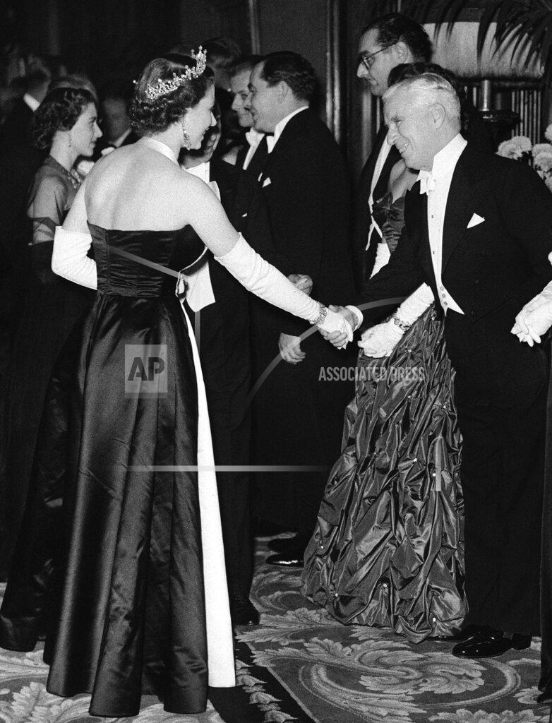 Uncredited FILE - Queen Elizabeth II shakes hands with actor Charlie Chaplin at the Empire Theatre in London on Oct. 27, 1952 for Royal Film Show, a benefit performance to aid the Cinematograph Trade Benevolent Fund. (AP Photo, File)