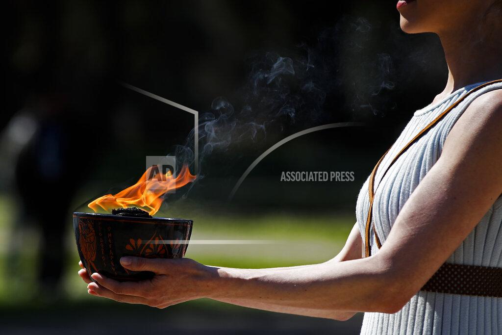 Thanassis Stavrakis An actress, playing the role of the priestess, holds the flame during the flame lighting ceremony at the closed Ancient Olympia site, birthplace of the ancient Olympics in southern Greece, Thursday, March 12, 2020. Greek Olympic officials are holding a pared-down flame-lighting ceremony for the Tokyo Games due to concerns over the spread of the coronavirus. Both Wednesday's dress rehearsal and Thursday's lighting ceremony are closed to the public, while organizers have slashed the number of officials from the International Olympic Committee and the Tokyo Organizing Committee, as well as journalists at the flame-lighting. (AP Photo/Thanassis Stavrakis)